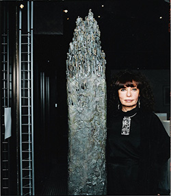 Portrait de Nisa Chevenement devant sa sculpture en bronze Tour